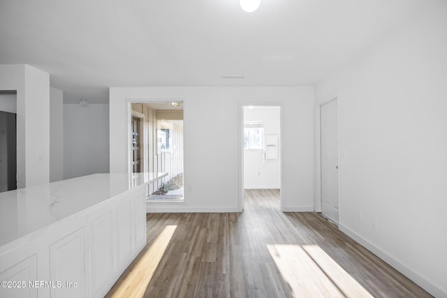 spare room featuring baseboards and light wood-style floors