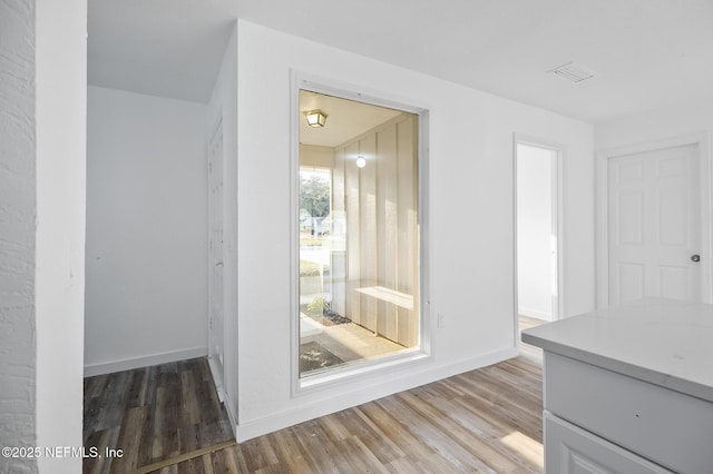 interior space with visible vents, wood finished floors, and baseboards