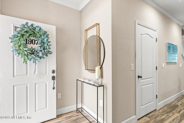 entrance foyer with baseboards, crown molding, and light wood finished floors