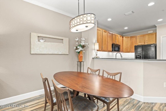 dining area with light wood finished floors, visible vents, baseboards, crown molding, and recessed lighting