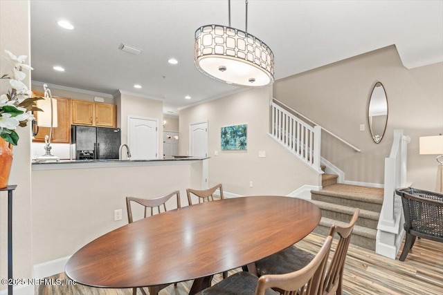 dining area with stairs, crown molding, wood finished floors, and recessed lighting