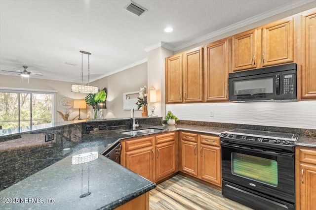 kitchen featuring visible vents, dark stone counters, ornamental molding, black appliances, and a sink