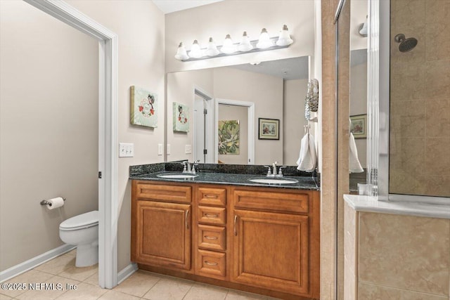 bathroom with toilet, tile patterned flooring, a tile shower, and a sink