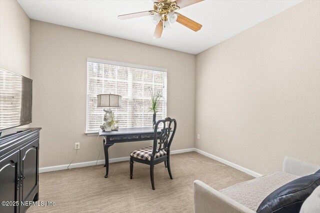 office space with light carpet, ceiling fan, and baseboards