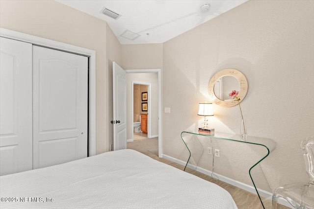 bedroom with a closet, visible vents, and baseboards