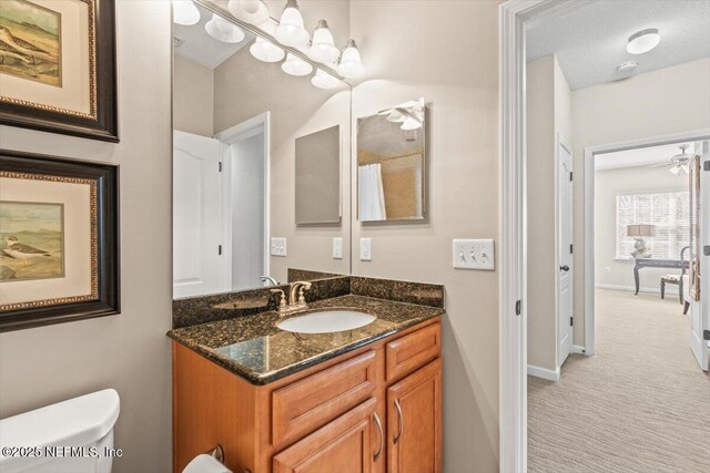 bathroom with baseboards, vanity, and toilet