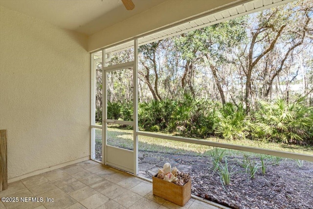 unfurnished sunroom featuring a ceiling fan