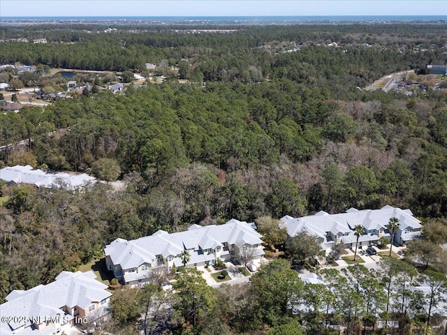 drone / aerial view featuring a residential view and a forest view