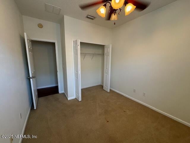 unfurnished bedroom featuring a closet, baseboards, visible vents, and carpet flooring