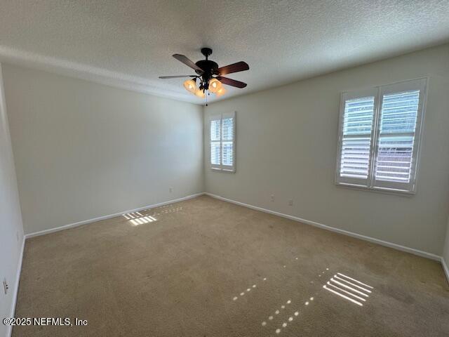 unfurnished room with ceiling fan, a textured ceiling, baseboards, and carpet floors