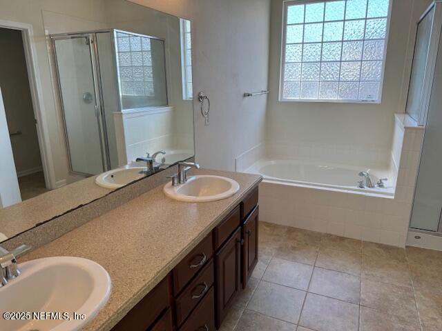 bathroom with a bath, a shower stall, and a sink