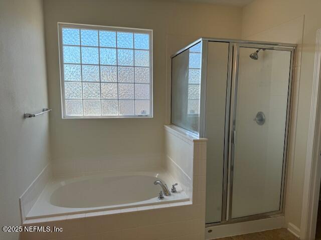 full bathroom with a shower stall and a garden tub