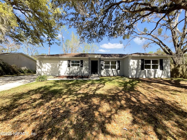 ranch-style home with a front lawn and fence