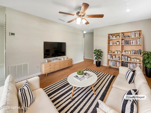 living area featuring a ceiling fan, wood finished floors, and visible vents