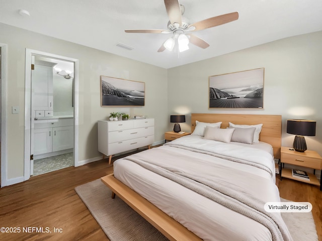 bedroom featuring visible vents, connected bathroom, ceiling fan, baseboards, and wood finished floors