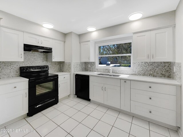 kitchen with under cabinet range hood, black appliances, and tasteful backsplash