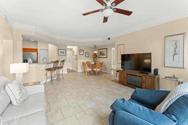 living room featuring ceiling fan, light tile patterned flooring, visible vents, baseboards, and ornamental molding