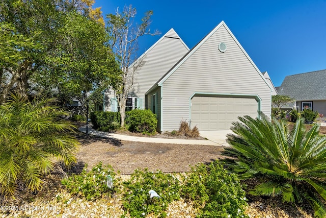 view of side of home with an attached garage and concrete driveway