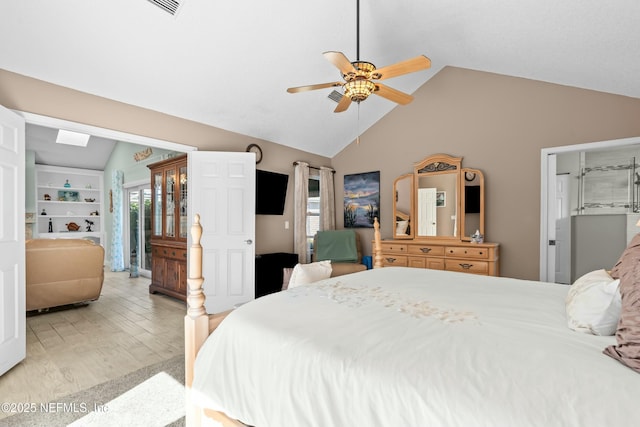 bedroom featuring vaulted ceiling, light wood-style flooring, and a ceiling fan