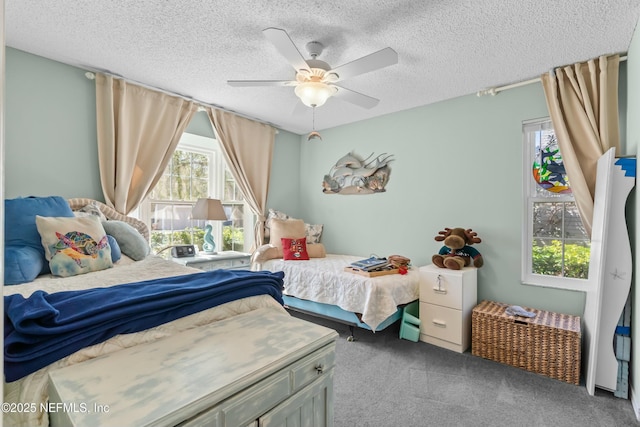 bedroom featuring a textured ceiling, ceiling fan, and carpet