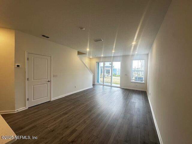 unfurnished room featuring dark wood-style floors and baseboards