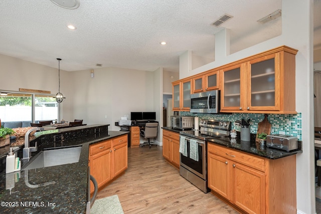 kitchen featuring visible vents, decorative backsplash, appliances with stainless steel finishes, light wood-style floors, and a sink