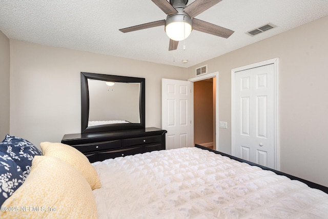 bedroom featuring visible vents, a textured ceiling, a closet, and ceiling fan