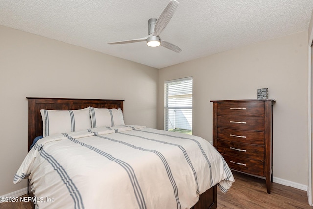 bedroom featuring baseboards, a textured ceiling, wood finished floors, and a ceiling fan