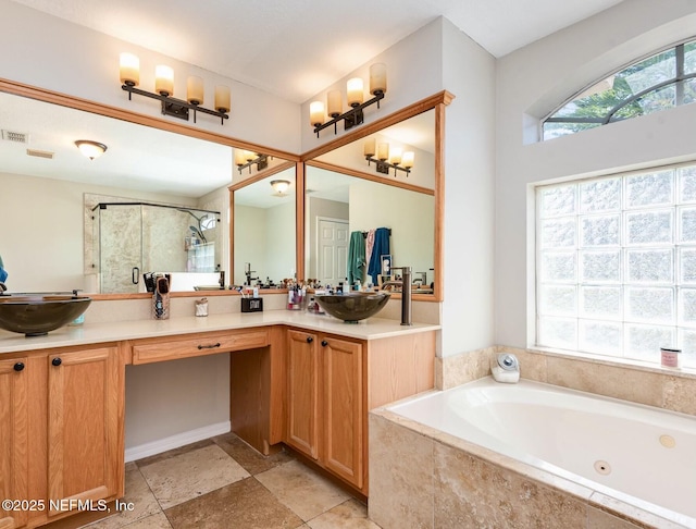 bathroom featuring a shower stall, double vanity, a whirlpool tub, and a sink