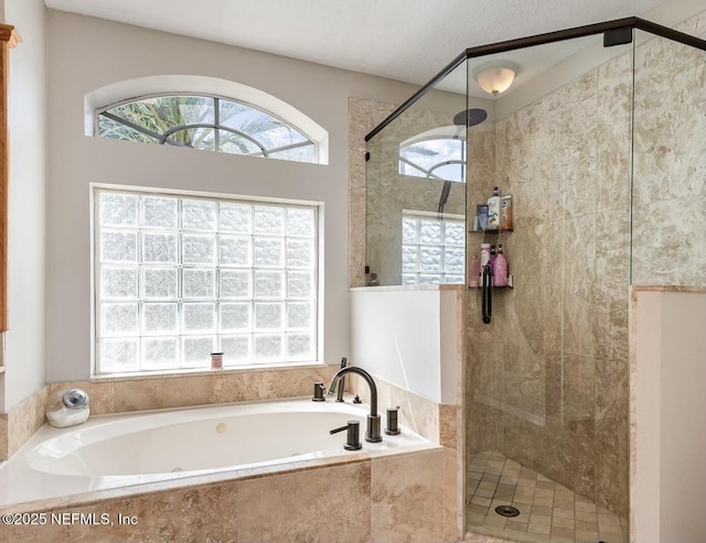 full bath featuring plenty of natural light, a shower stall, and a garden tub