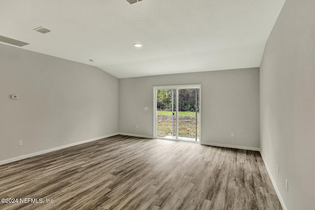 unfurnished room featuring visible vents, wood finished floors, and baseboards