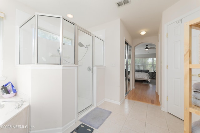 ensuite bathroom featuring tile patterned floors, visible vents, connected bathroom, a shower stall, and ceiling fan