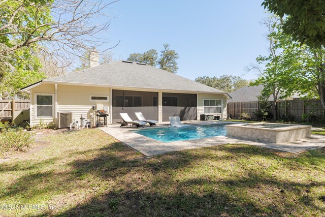 rear view of property with a patio, a fenced backyard, a sunroom, a chimney, and a lawn