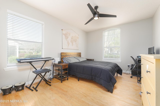 bedroom with multiple windows, ceiling fan, baseboards, and wood finished floors