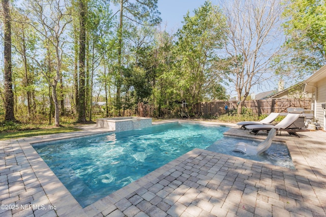 view of swimming pool featuring a fenced backyard, grilling area, a pool with connected hot tub, and a patio