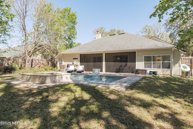 back of house featuring roof with shingles, a yard, a fenced backyard, a sunroom, and a chimney