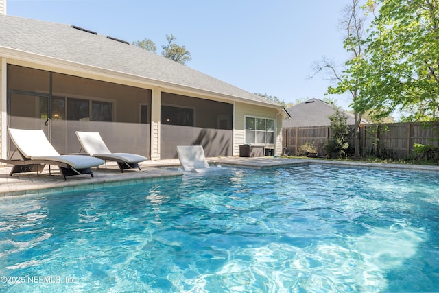 view of pool with a patio, fence, a fenced in pool, and a sunroom