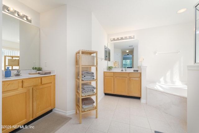 full bathroom with a bath, two vanities, a healthy amount of sunlight, and tile patterned flooring