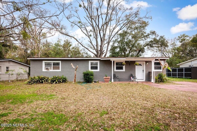 ranch-style house featuring a front yard, brick siding, and fence