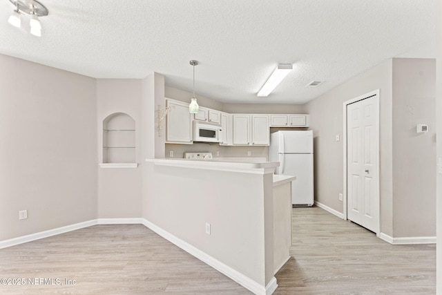 kitchen featuring light countertops, white appliances, white cabinetry, and light wood finished floors