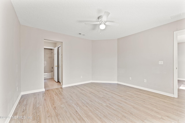 empty room with baseboards, visible vents, ceiling fan, a textured ceiling, and light wood-type flooring