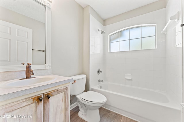 full bath featuring toilet, shower / washtub combination, wood finished floors, and vanity