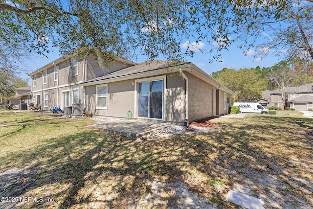 rear view of house featuring a yard, central AC unit, and a patio area