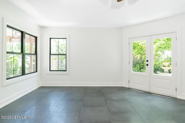 unfurnished room with ceiling fan, french doors, and baseboards