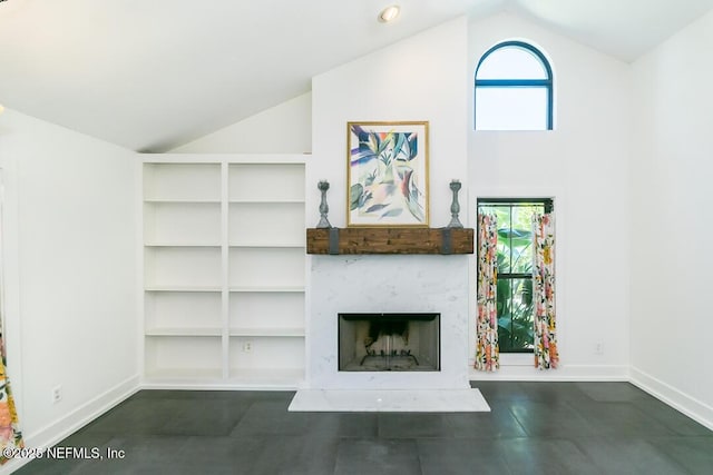 unfurnished living room featuring high vaulted ceiling, plenty of natural light, a fireplace, and baseboards