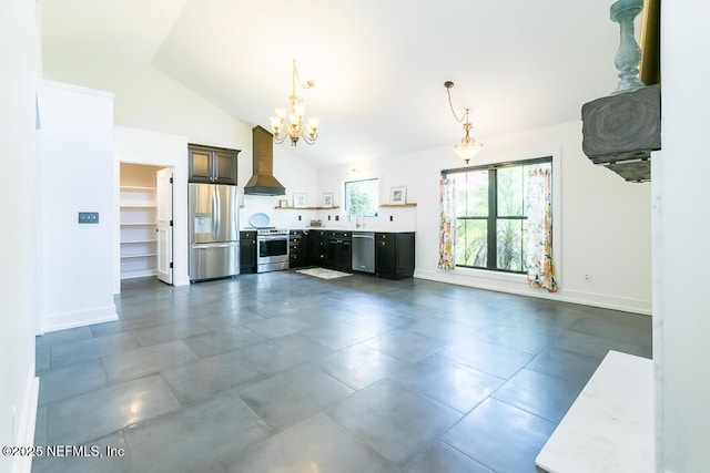 kitchen featuring a chandelier, light countertops, appliances with stainless steel finishes, wall chimney exhaust hood, and pendant lighting