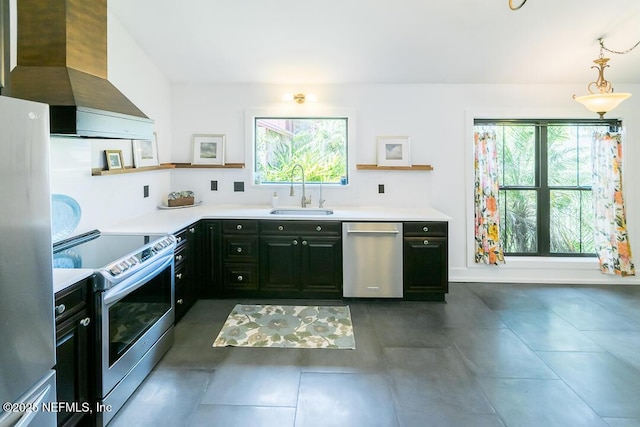 kitchen featuring stainless steel appliances, a healthy amount of sunlight, a sink, and wall chimney exhaust hood