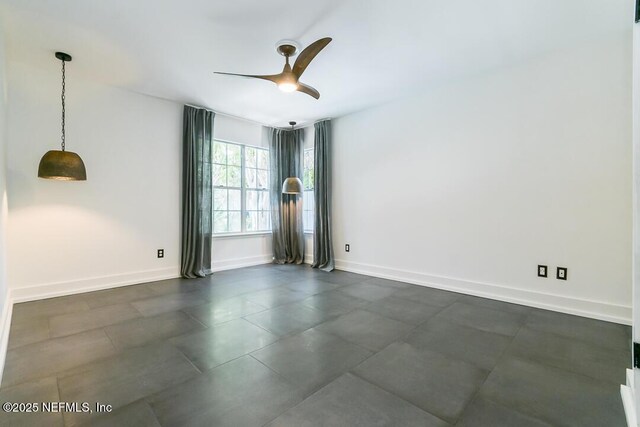 empty room featuring baseboards and a ceiling fan