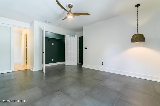 empty room featuring baseboards, visible vents, and a ceiling fan