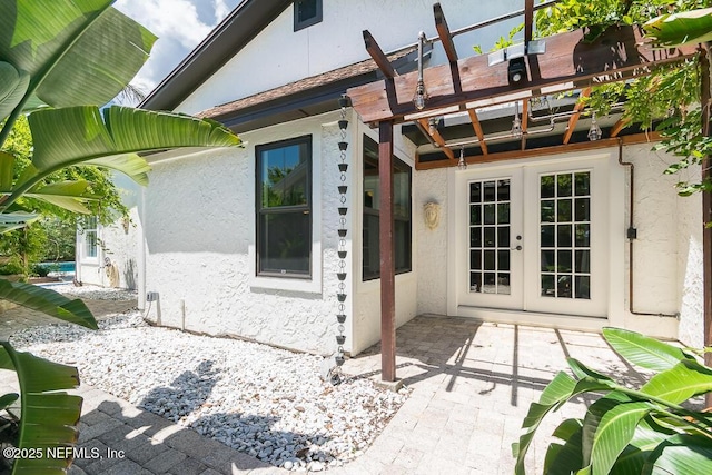 entrance to property featuring french doors and stucco siding